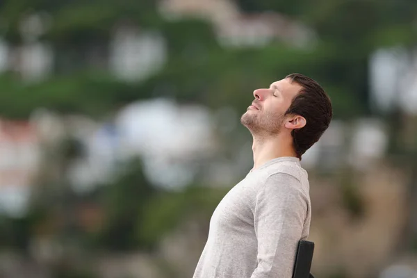 Uvolněný muž na lavičce dýchá čerstvý vzduch — Stock fotografie