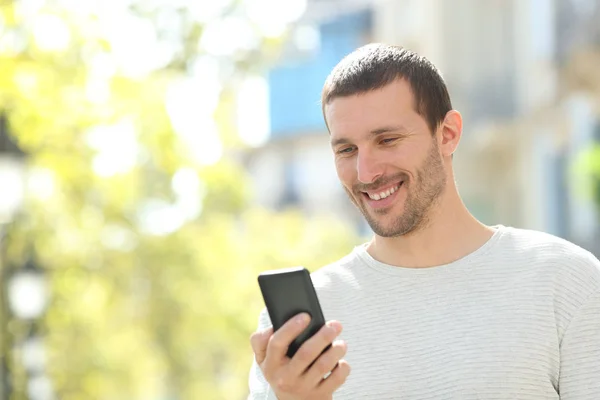 Šťastný dospělý muž kontroluje text v mobilním telefonu — Stock fotografie