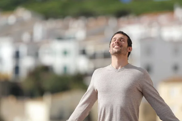 Uomo felice che respira aria fresca in una città rurale — Foto Stock