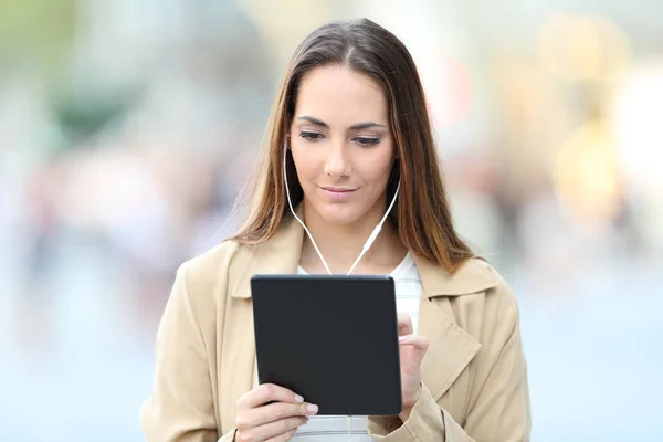 Serious woman e-learning using tablet and earbuds — 스톡 사진
