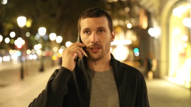 Vista Frontal Hombre Serio Caminando Hablando Por Teléfono Noche Calle — Vídeo de stock