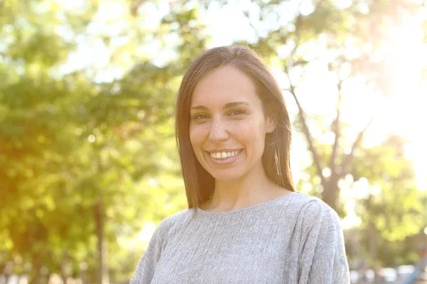 Portrait of a happy adult woman looking at camera in a park — Stock Photo, Image