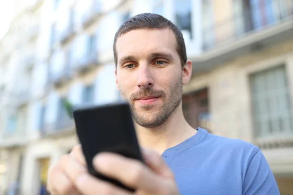 Gros plan d'un adulte sérieux utilisant un téléphone intelligent — Photo