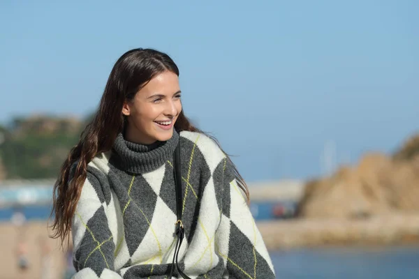 Glückliches Mädchen im Pullover mit Blick auf den Strand — Stockfoto