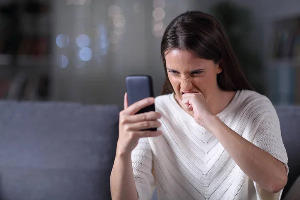 Chica enojada comprobando el contenido del teléfono en la noche —  Fotos de Stock