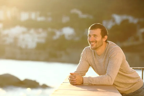 Turista feliz olha para longe em uma varanda ao pôr do sol — Fotografia de Stock