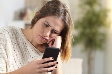 Evde akıllı telefon tutan sıkıcı kız.