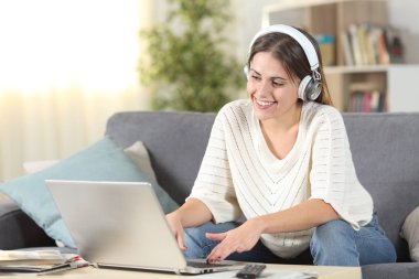 Kulaklık ve dizüstü bilgisayar kullanarak mutlu kadın e-öğrenimi