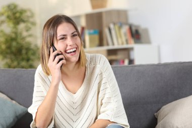 Evde cep telefonuyla konuşan mutlu kız.