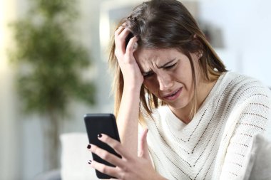Üzgün kız evde akıllı telefon tutmaktan şikayetçi.