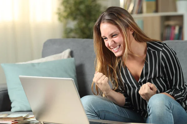 Євфорична жінка святкує успіх перевірки вмісту ноутбука — стокове фото