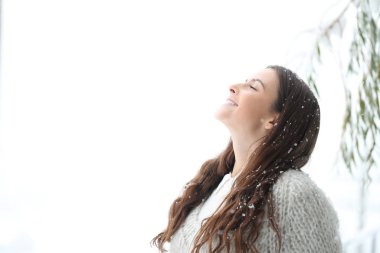 Mutlu kız kışın kar altında temiz hava soluyor.