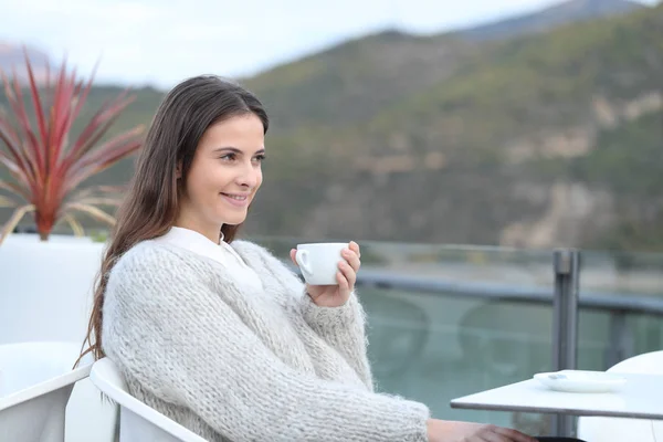 Chica feliz mira hacia otro lado sosteniendo taza de café en una terraza —  Fotos de Stock