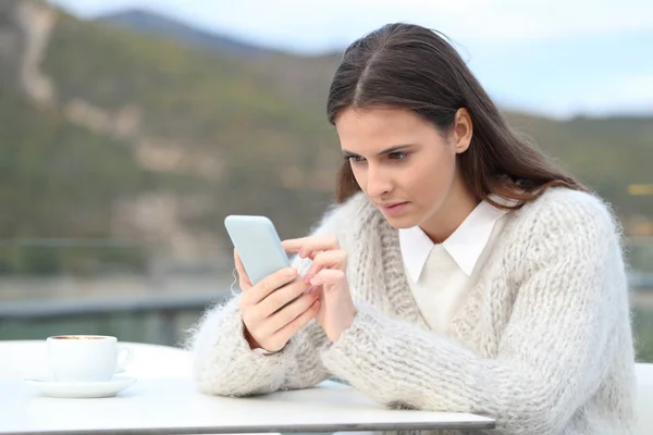 Koncentrerad tjej använder telefon på ett kafé — Stockfoto