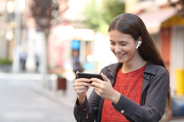 Gelukkig tiener kijken media op smart phone in de straat — Stockfoto