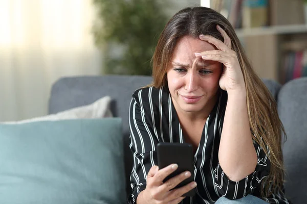Triste dona de casa verificando telefone celular em casa — Fotografia de Stock