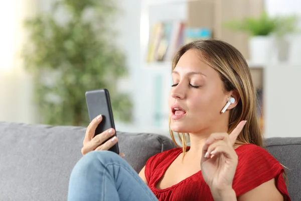 Mujer escuchando música y cantando en casa — Foto de Stock