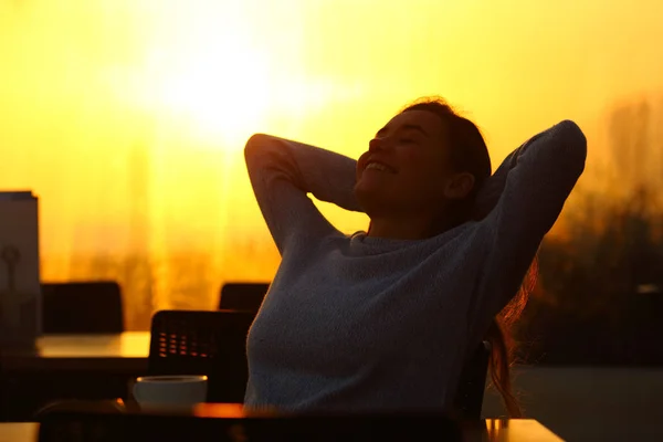 Femme détendue se reposant au coucher du soleil dans une terrasse de café — Photo