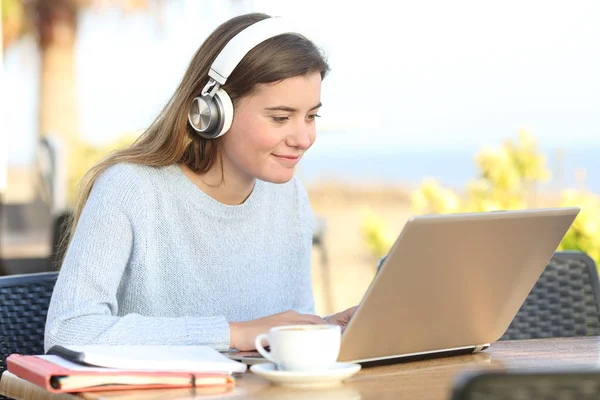 Студентське електронне навчання з навушниками та ноутбуком у барі — стокове фото