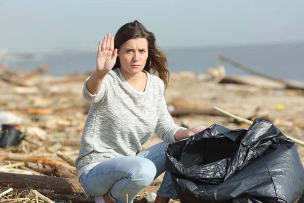 Voluntario enojado limpiando una parada de gestos de playa — Foto de Stock