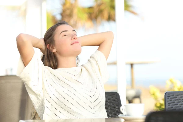 Menina relaxante sentado em um terraço na praia — Fotografia de Stock