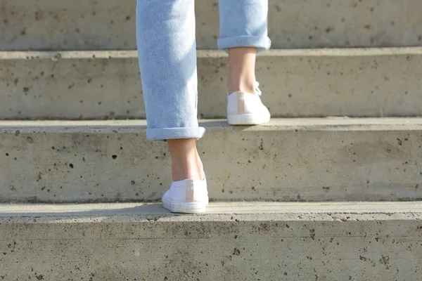 Woman legs wearing sneakers walking up stairs — 스톡 사진