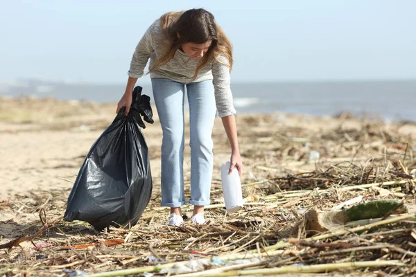 Joven voluntario limpiando una playa sucia después de la tormenta —  Fotos de Stock
