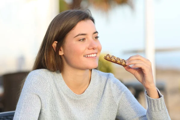 Счастливая девушка закусывает на террасе кофейни — стоковое фото