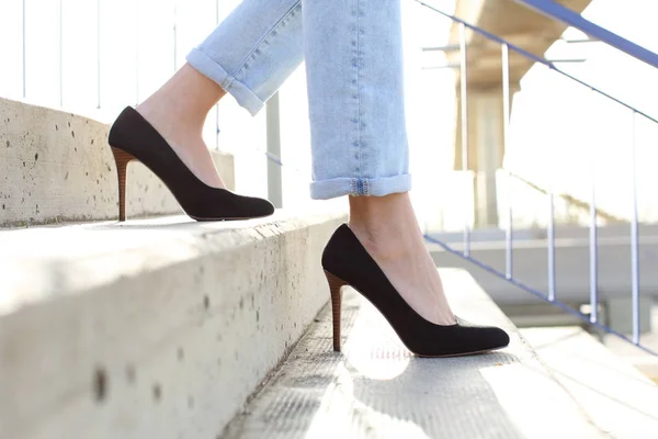 Perfil de las piernas de mujer con tacones altos bajando escaleras — Foto de Stock