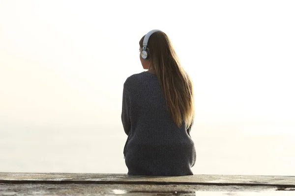 Magányos nő zenét hallgat, nézi a horizontot. — Stock Fotó