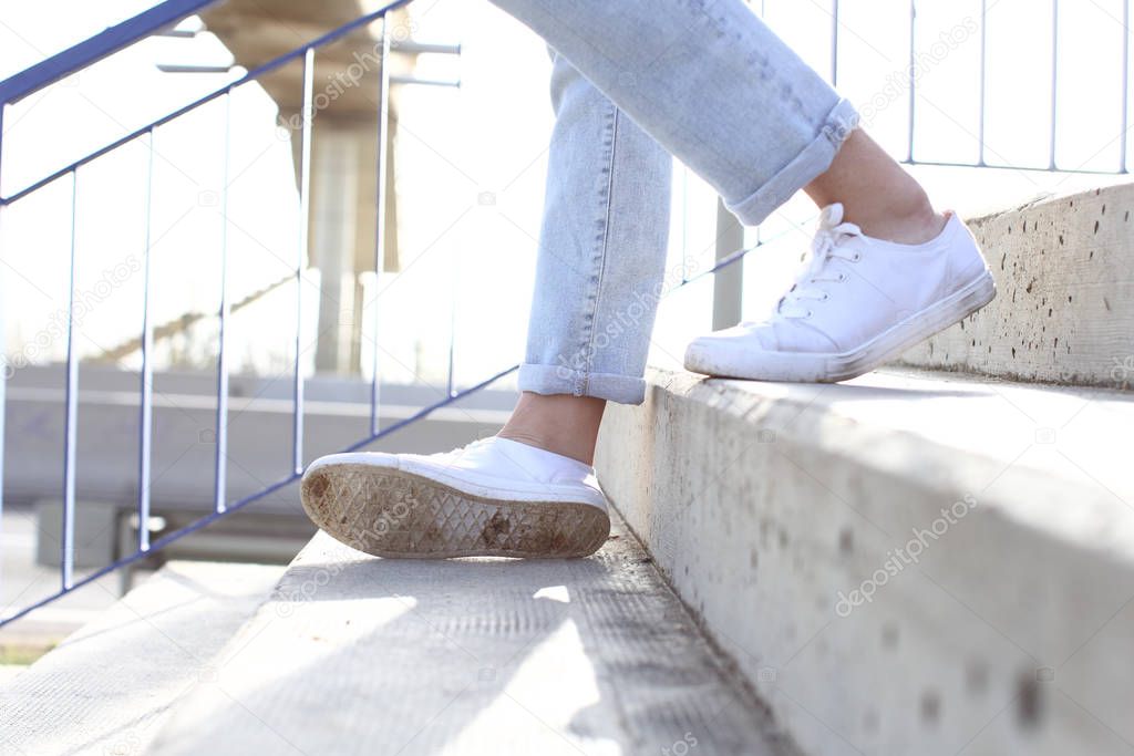 Girl with sneakers walking down stairs and sprain ankle