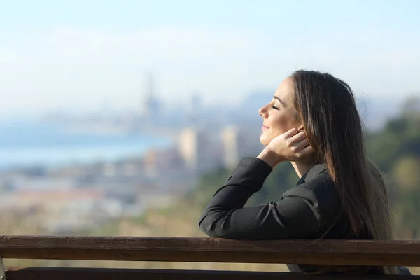 Geschäftsfrau entspannt sich mit geschlossenen Augen auf einer Bank — Stockfoto