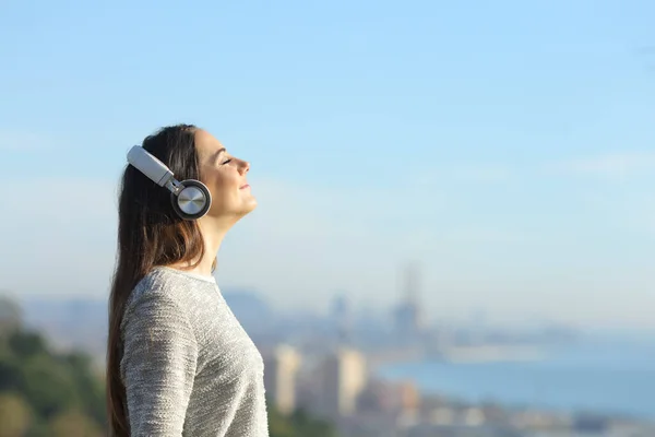 Дівчина слухає музику дихає стоячи на відкритому повітрі — стокове фото