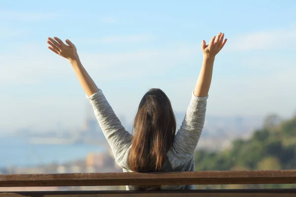 Glückliche Frau hebt die Arme und blickt auf den Horizont — Stockfoto