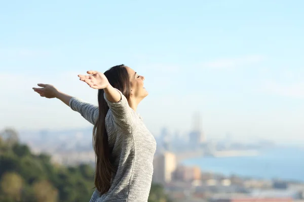 Mujer feliz estirando los brazos respirando aire fresco al aire libre —  Fotos de Stock