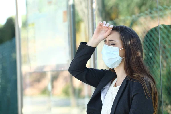 Woman wearing a mask complaining suffering head ache — Stok fotoğraf