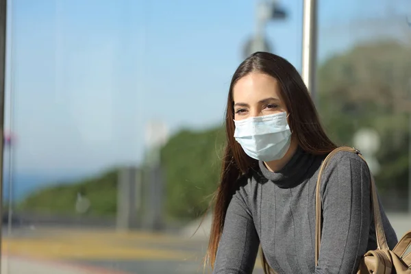 Egy maszkos nő, aki megelőzi a buszmegállóban való fertőződést. — Stock Fotó