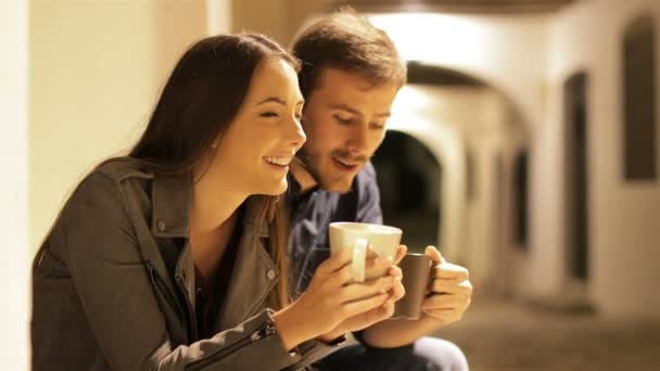 幸せなカップルの話と路上で夜のコーヒーを飲む — ストック動画