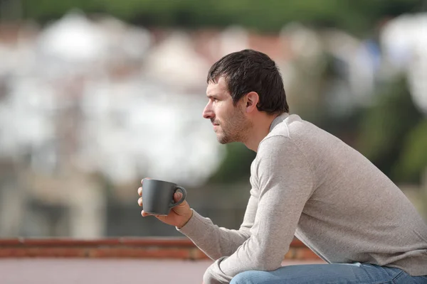 Kentte Oturmuş Elinde Kahve Fincanı Olan Manzarayı Seyreden Ciddi Bir — Stok fotoğraf