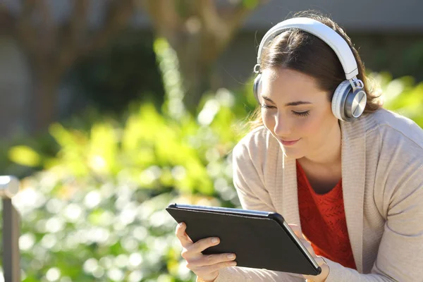 Kulaklık Takan Bir Kadın Medyayı Izliyor Tablette Öğreniyor Parkta Oturuyor — Stok fotoğraf