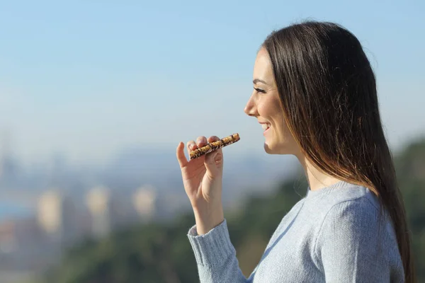 街の郊外でスナックバーを食べながら景色を眺めながら幸せな女の子 — ストック写真