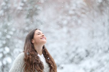 Mutlu bir genç kızın portresi. Kışın karlı bir günün tadını çıkarıyor.