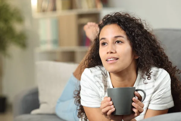 Pensive Latin Vrouw Drinken Koffie Liggend Een Bank Thuis — Stockfoto