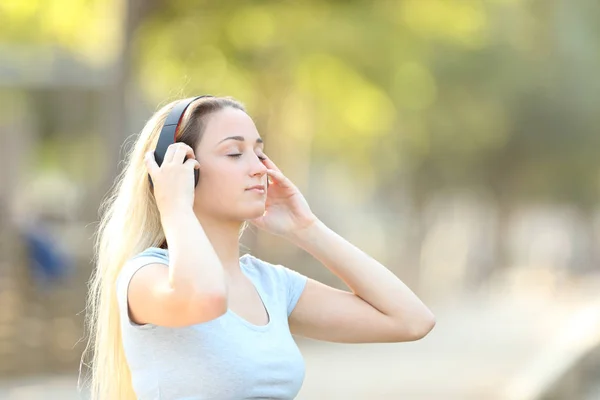 夏に公園の背景を持つ音楽を聴く10代の少女 — ストック写真