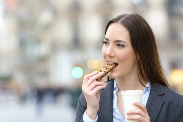 Portrait Satisfied Business Woman Eating Cereal Snack Bar Holding Coffee — Zdjęcie stockowe