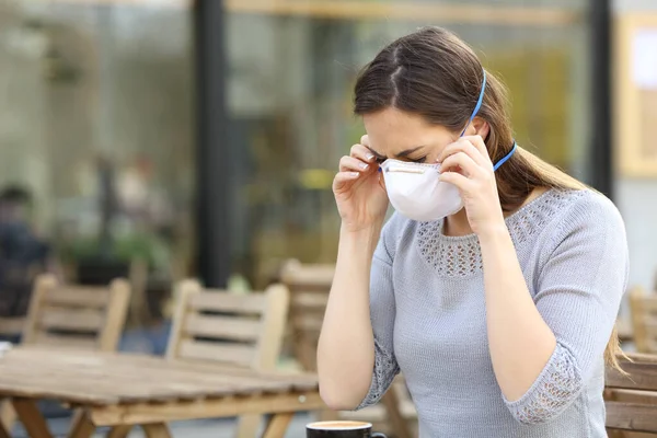 Mujer Seria Poniéndose Una Máscara Protectora Para Prevenir Contagio Terraza — Foto de Stock