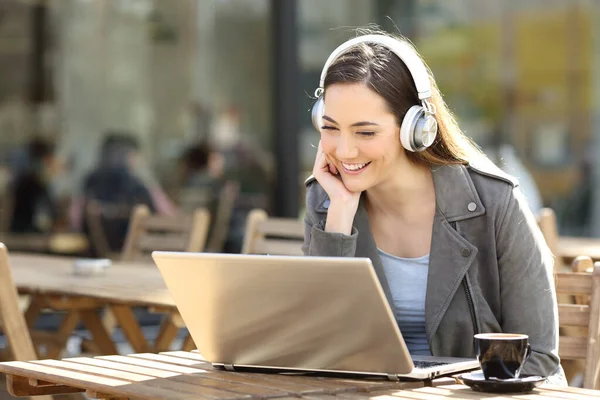 Happy Woman Oglądanie Treści Multimedialnych Laptopie Słuchawkami Tarasie Restauracji — Zdjęcie stockowe