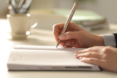 İş kadınlarının elleri, gece ofiste gündemle ilgili notlar yazarken kapanıyor.