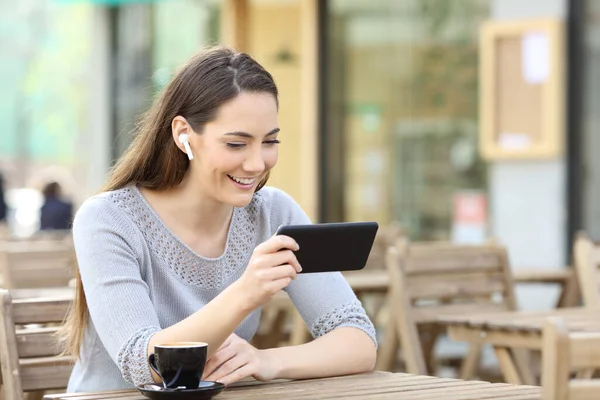 Happy Woman Earbuds Watching Video Content Online Smarphone Coffee Shop — стоковое фото