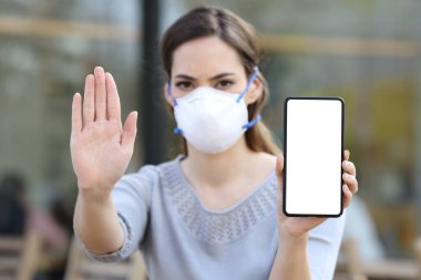 Koruyucu maskeli kız, kahve dükkanında boş telefon ekranı göstermekten kaçınmayı bırak.